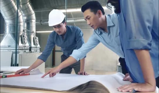 An AdvanTEC team lead and engineer discussing and analyzing a blueprint.